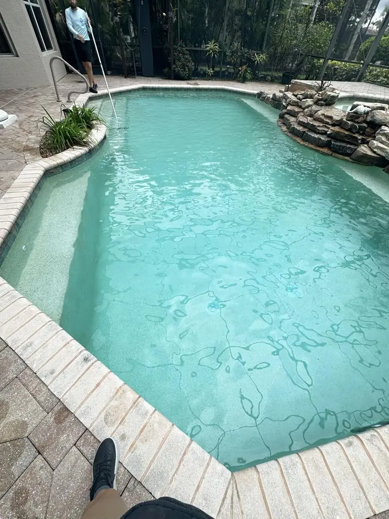 Geometric pool with rock waterfall feature and clean waterline tile