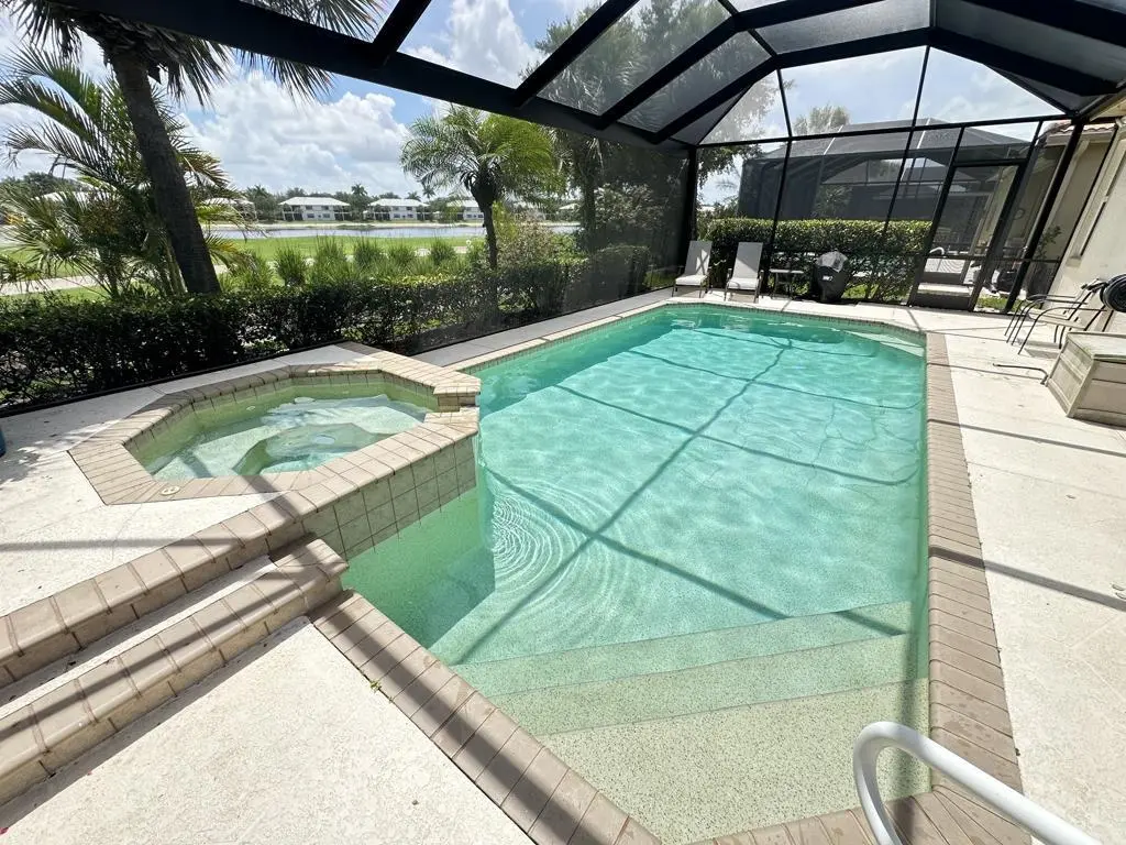 Residential pool with attached spa overlooking a lake view in Naples, FL