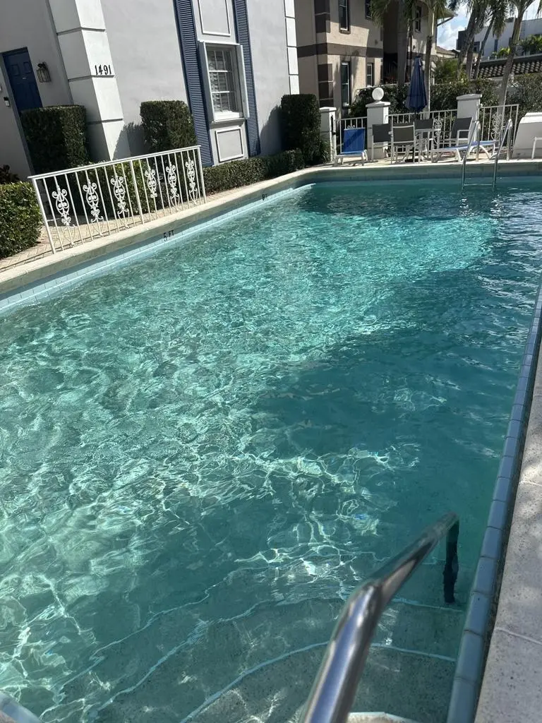 Rectangular pool with handrail and patio seating cleaned weekly in Naples, FL