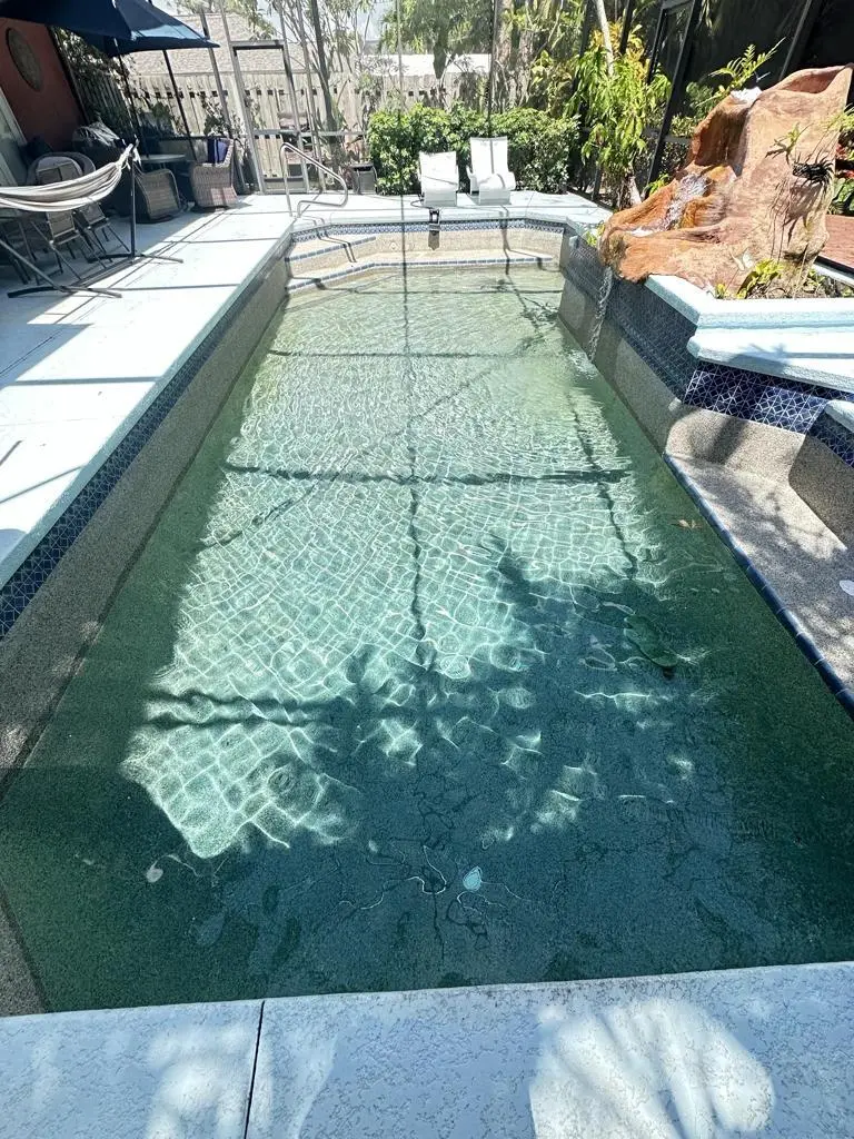 Lanai pool with rock waterfall and clear water serviced by ABA Pool Cleaning