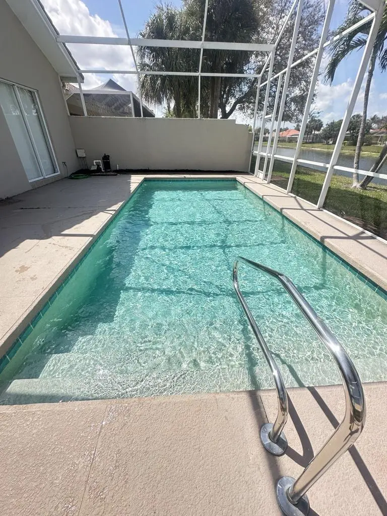 Rectangular lanai pool with handrail and debris-free surface in Naples, FL